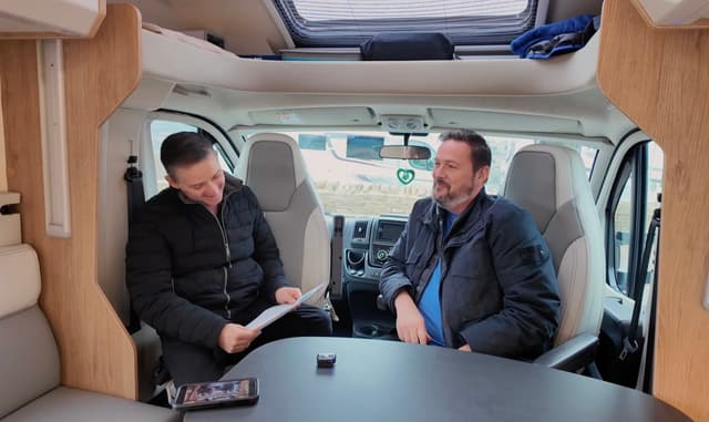 Gary going through paperwork with a customer inside a motorhome