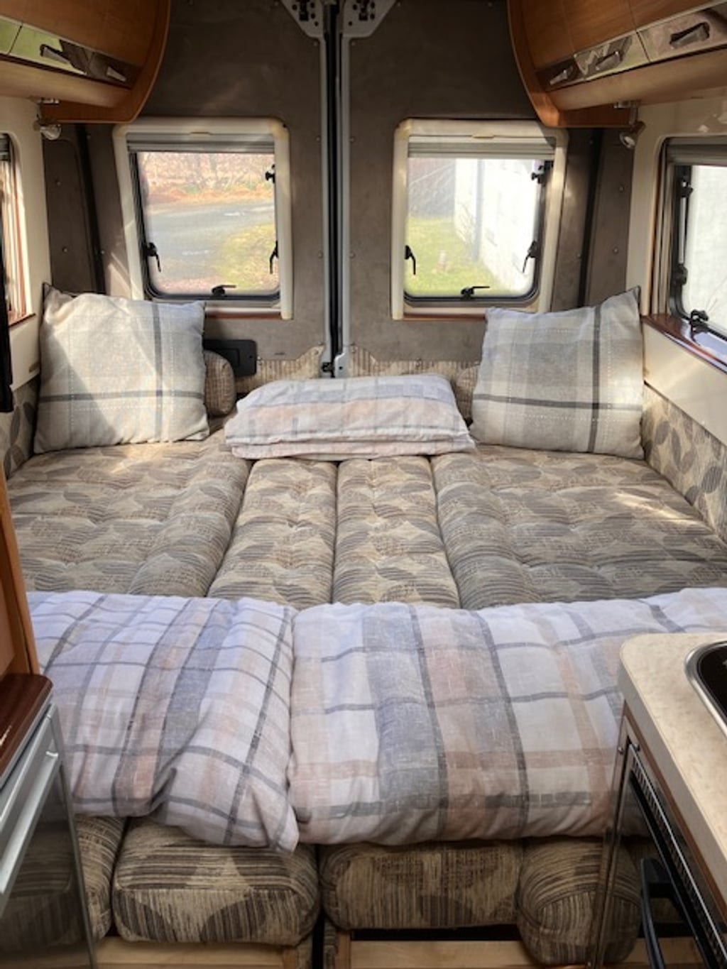 The Autocruise Rhythm's rear lounge made up into a double bed with cushions