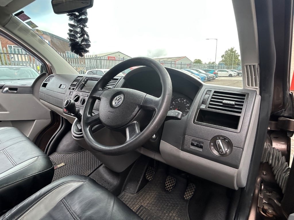 The cab of the Volkswagen Transporter from the passenger side, showing the steering wheel, dashboard and stereo