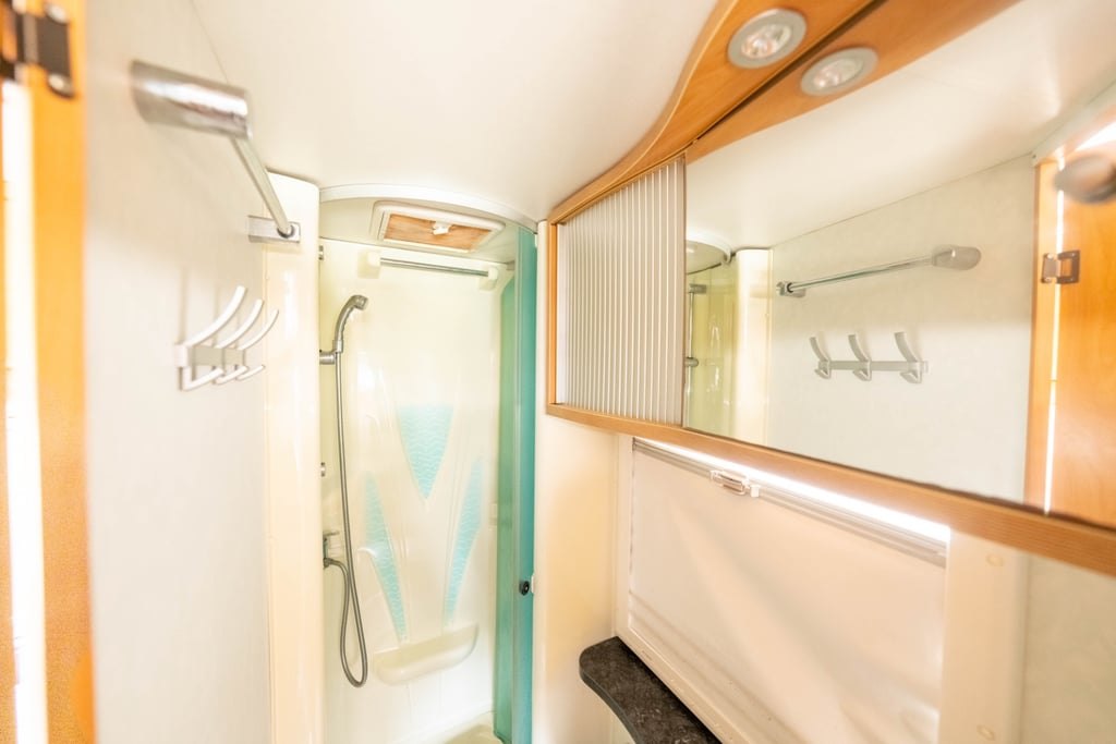 The separate shower cubicle in the Chausson Welcome 85, with a folding door and grab rail