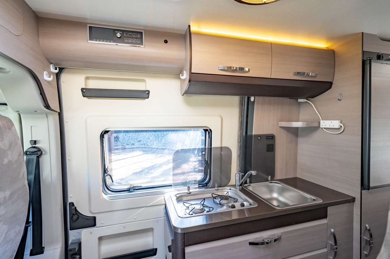 The Hobby Vantana's galley and living area, looking back through the van with the kitchen on the left and a large side window
