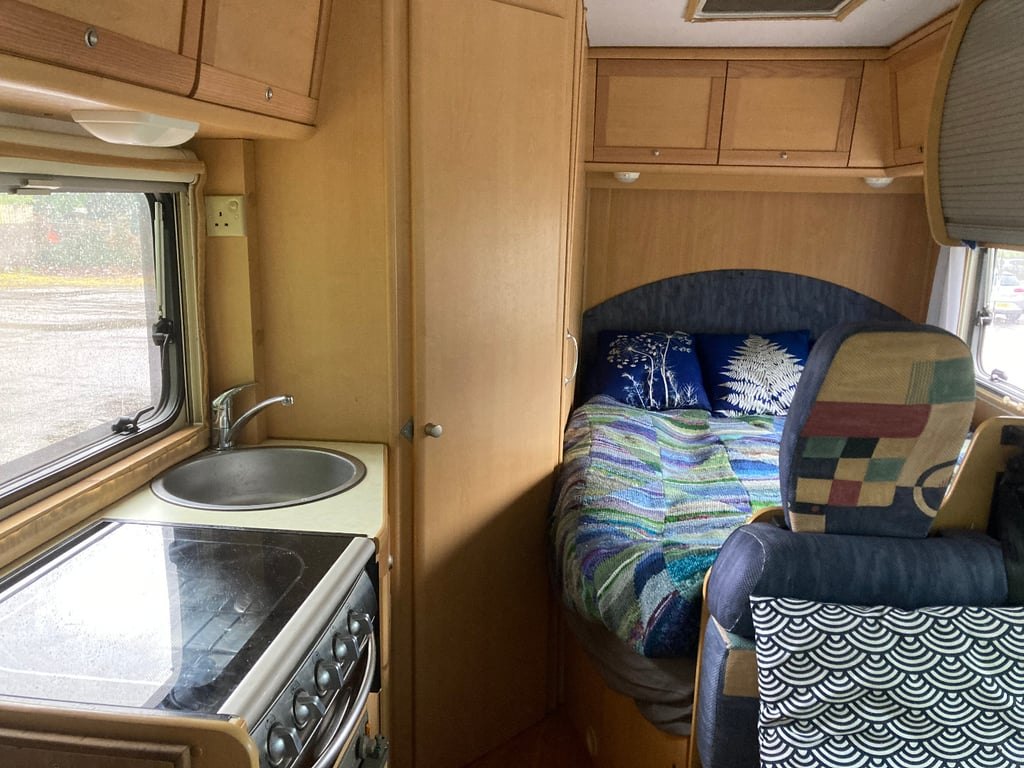 The kitchen of the Auto-Roller 15 showing the hob, oven and sink, with the side dinette beyond
