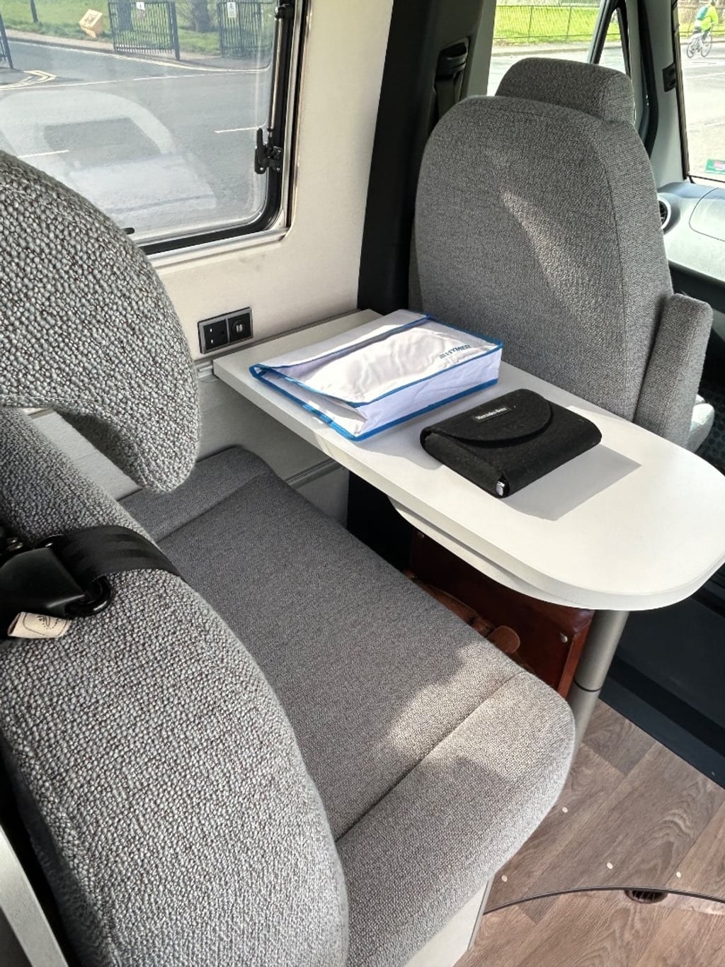 The lounge of the Hymer Free S 600 with swivel cab seats turned to face a mounted table