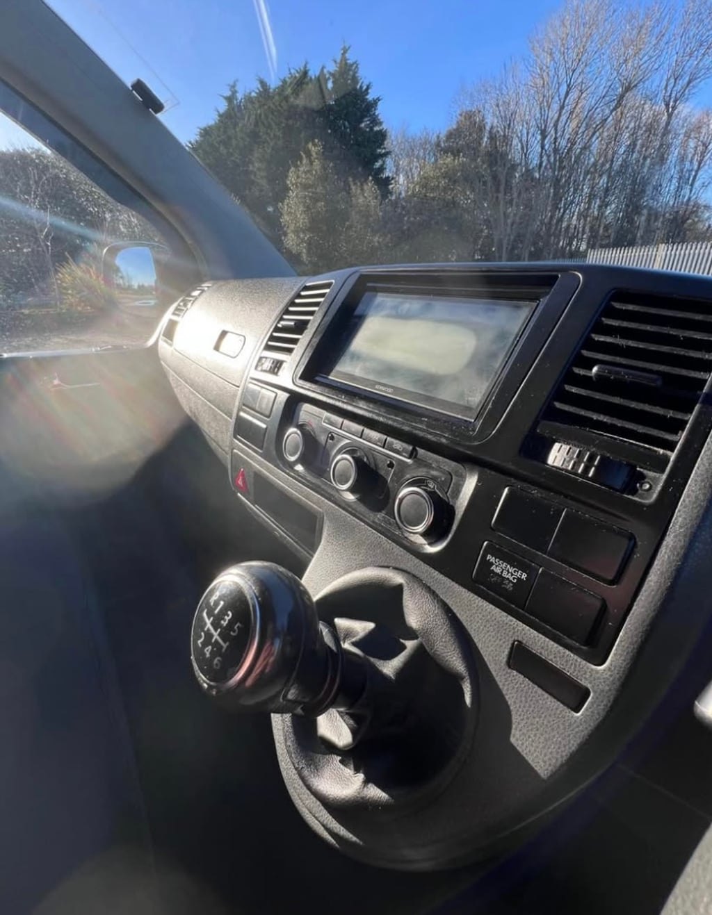 The cab of the VW Transporter showing the steering wheel, dashboard, radio and gear lever